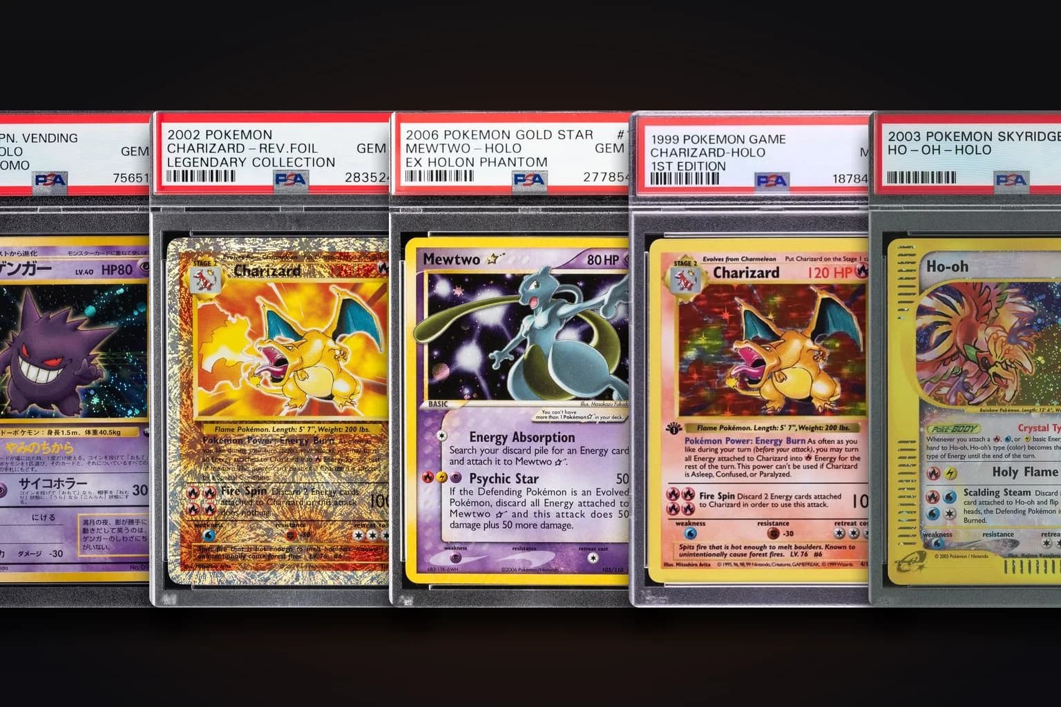 A row of real graded Pokémon slabs lined up together — Charizard, Mewtwo, Ho-Oh, Gengar and more